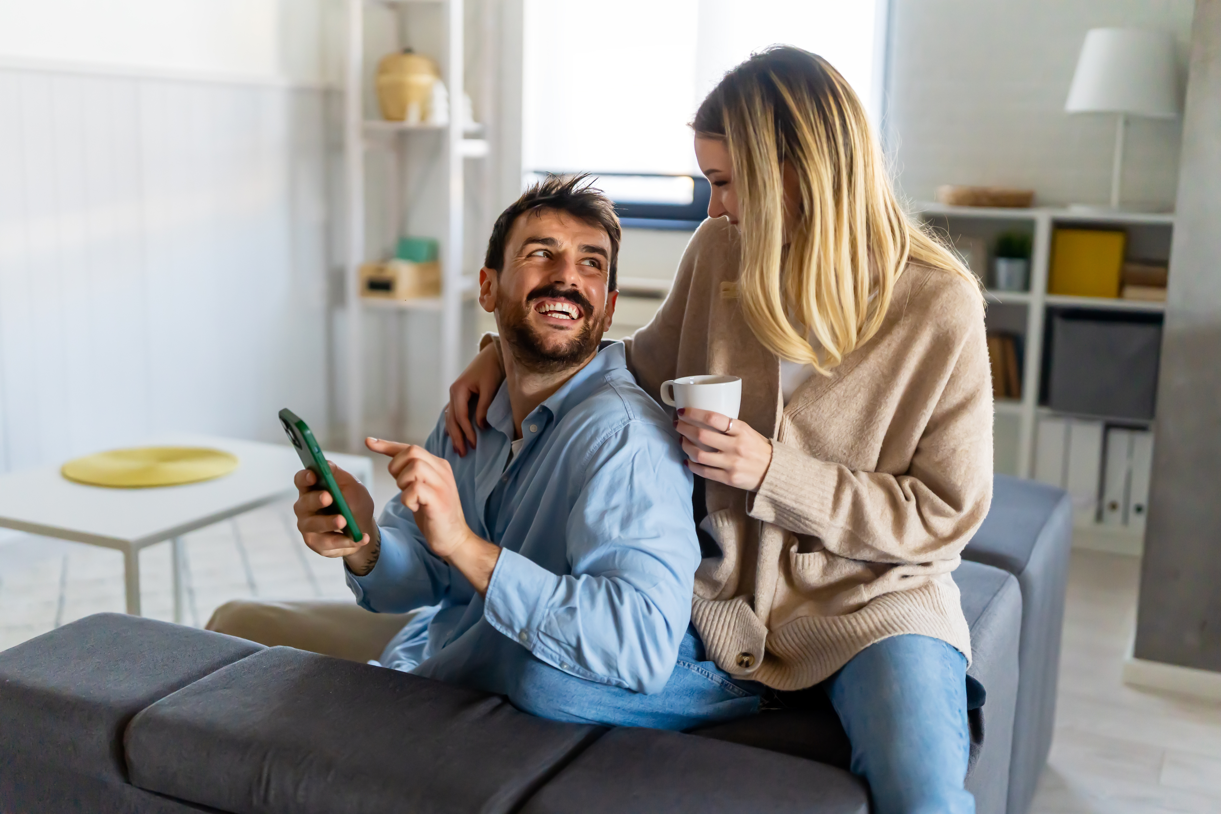 Pareja feliz usando smartphone para gestionar su propiedad